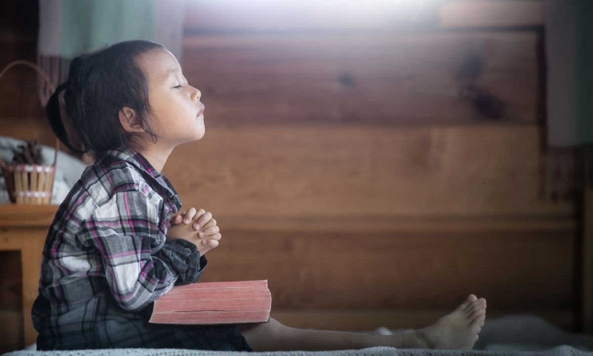 criança orando - o amor de deus nos constrange