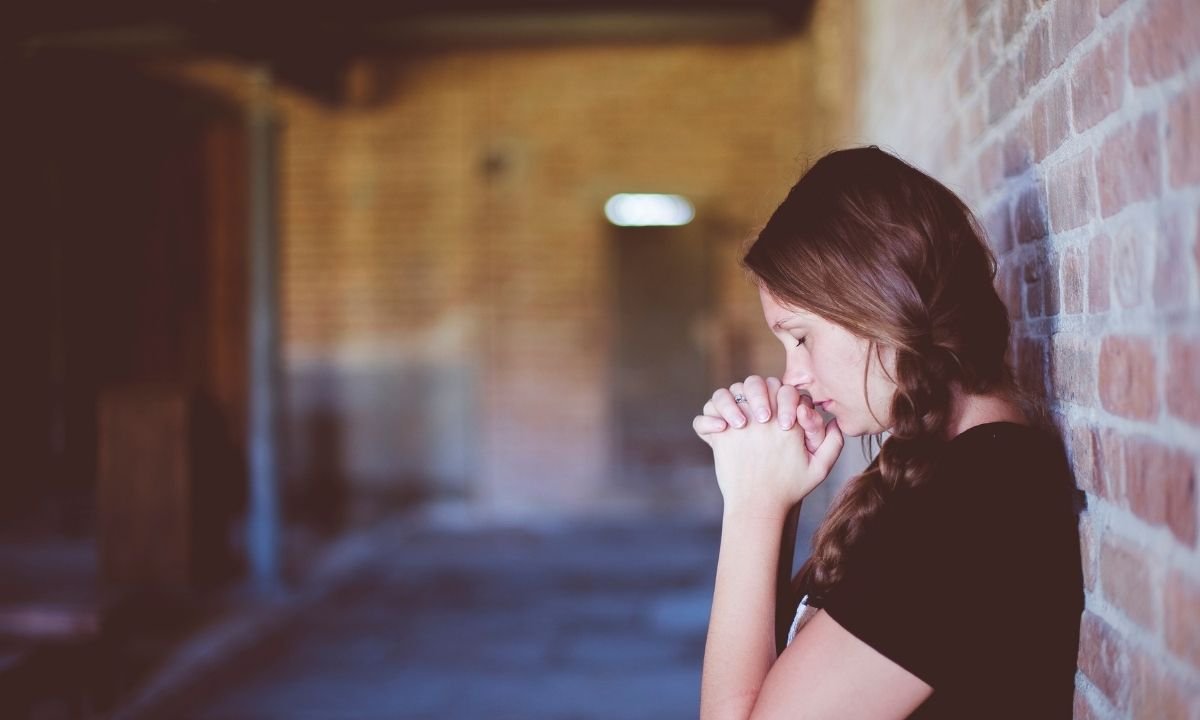 Palavra de recomeço na Bíblia - mulher orando, pois Deus ouve nossas orações